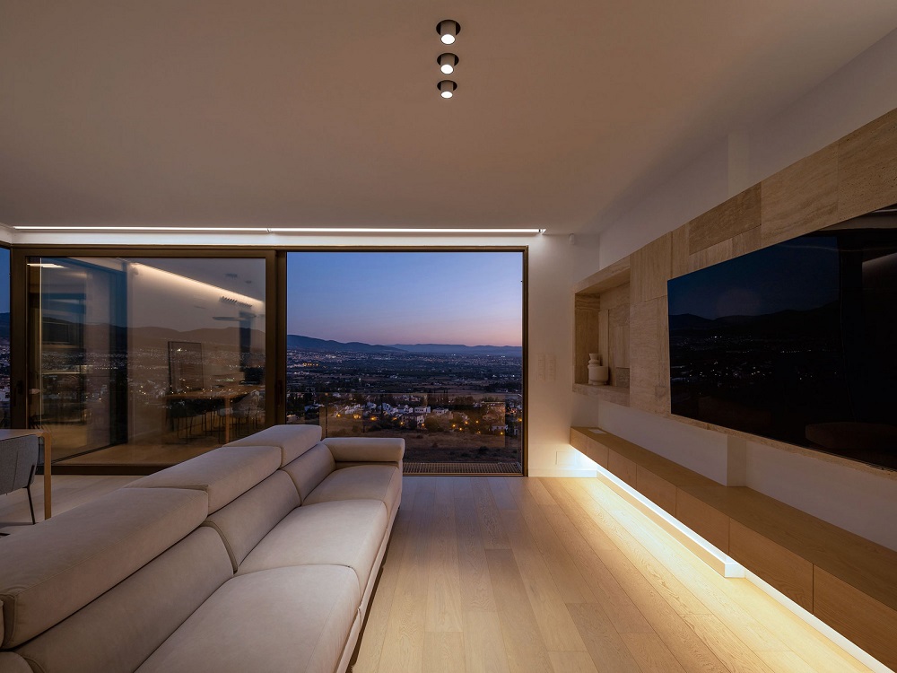 Modern living room with recessed ceiling lighting, adjustable spotlights and layered architectural illumination